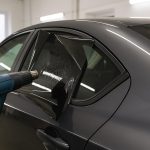 Car window being tinted by a professional technician at an auto service center