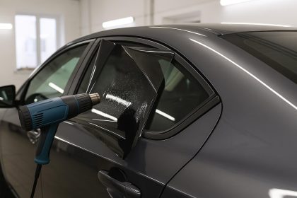Car window being tinted by a professional technician at an auto service center