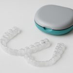 Clear Invisalign aligners on a dental tray, highlighting orthodontic treatment options in Surrey