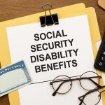 Social Security Disability Benefits application form with pen and official documents on desk