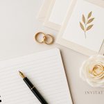 Elegant wedding stationery flat lay with pen, notebook, and roses for wedding writing inspiration