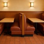 Modern restaurant booths with upholstered seating and wooden tables in a stylish dining area