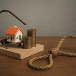 Stack of loan documents with a calculator and debt warning sign, illustrating personal loan risks