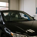 Auto glass replacement technician repairing car windshield in Sterling Heights, MI.