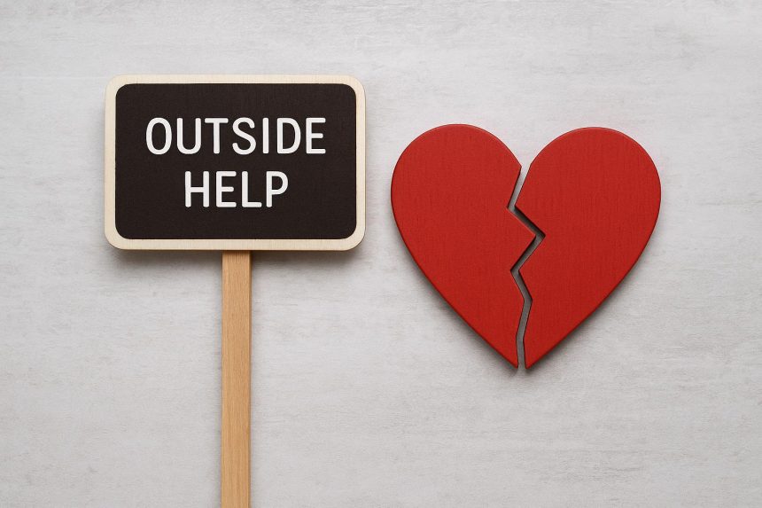 Couple sitting apart on sofa, looking concerned, showing tension in romantic relationship