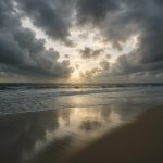 Calm landscape with scattered debris under clearing skies after a severe storm