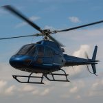 Modern helicopter in flight illustrating speed and aerodynamics against a blue sky background