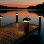 Solar lighting fixtures installed along a wooden dock over water at sunset