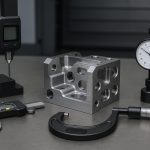 Digital caliper measuring a machined metal part on a CNC workbench for precision inspection