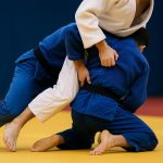 Judo competitors demonstrating legal leg grips during a match under current judo rules